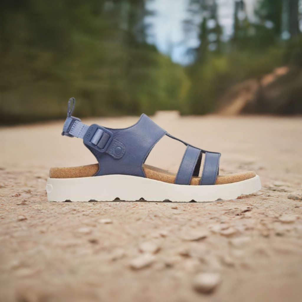 Women's Merrell Fleur Backstrap Sandal in navy blue shown outdoors on a trail, highlighting its rugged sole and stylish design for active lifestyles.
