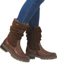Brown Remonte D0B80 women's winter boots styled with jeans, showcasing mid-calf height, inner zipper, and flexible cuff design.