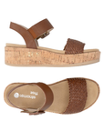 Pair of Brown wedge sandals with black woven toe strap, buckled back strap, tan Remonte logo's footbed, faux cork midsole and tan outsole.