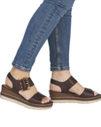 Dark Brown wedge sandals worn with blue jeans.