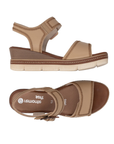 Pair of Tan wedge sandals with brown buckle, accent zig-zag stitching, tan Remonte logo'd footbed and tan-white outsole.