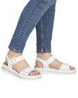 White backstrap sandals worn with blue jeans.