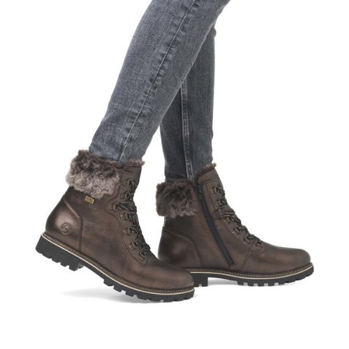 Model wearing the Remonte D8483 waterproof lace-up ankle boots with faux fur collar, styled with jeans for a winter-ready look.