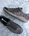 Brown Remonte R1402 lace-up sneaker displayed on stone surface, showcasing textured leather and side zipper for easy wear.