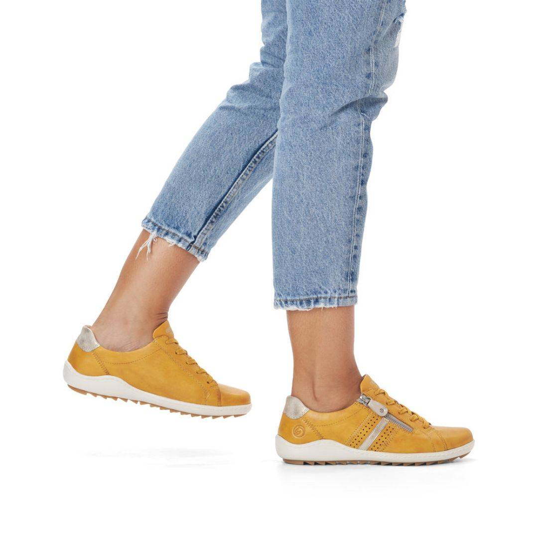 Model wearing yellow Women's Remonte R1432 Lace-Up Sneakers with jeans, highlighting casual comfort and flexible fit.