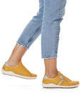 Model wearing yellow Women's Remonte R1432 Lace-Up Sneakers with jeans, highlighting casual comfort and flexible fit.