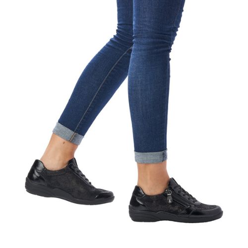 Model wearing black Remonte R7637 Lace-Up Sneakers with stretch material, styled with rolled denim for casual comfort.