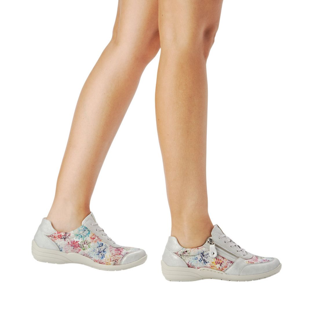 Model wearing silver multicolor Remonte R7637 Lace-Up Sneakers, styled for casual wear with stretch material for added comfort.