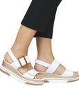 Model wearing white Remonte D1P50 Platform Wedge sandals, styled with black pants for a chic summer look with comfort.