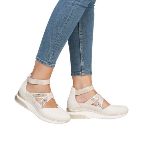 Model wearing off-white Remonte D2411 women's sneaker shoes with jeans, showcasing stylish wedge heel and supportive ankle strap design.