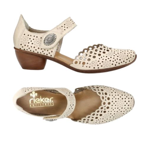 Pair of Beige heeled open sided Mary-Janes with Velcro ankle strap, floral pattern, decorative perforations and a low stacked heel.