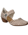 Beige heeled open sided Mary-Jane with Velcro ankle strap, floral pattern, decorative perforations and a low stacked heel.