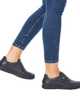 Model wearing navy Women's Rieker 48951 Velcro Shoes with jeans, demonstrating casual style and flexible, bunion-friendly fit.