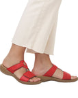 Red slide sandals worn by a model in beige capris.