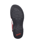 Treaded black rubber outsole of sandal with lines and circle pattern and red Rieker logo on heel.