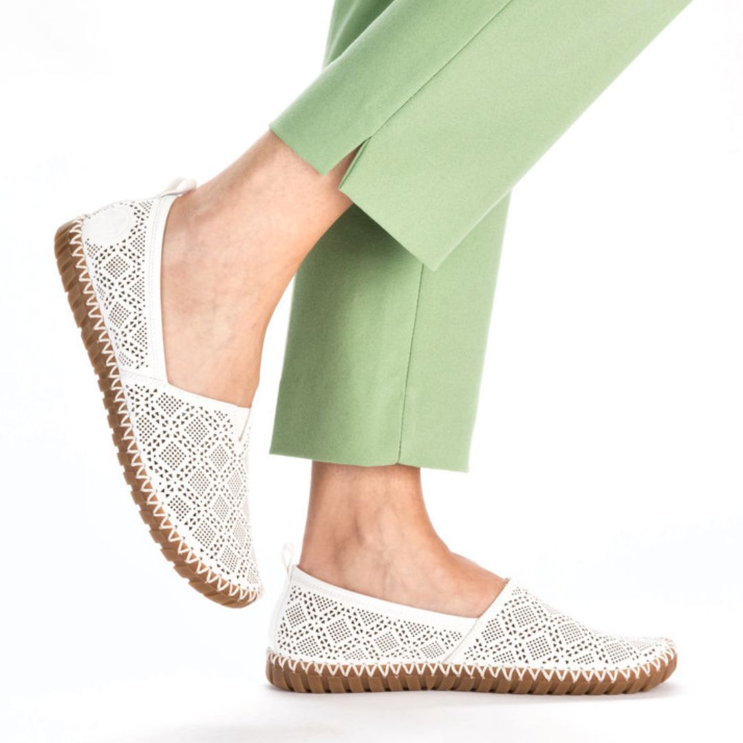 Model wearing Rieker M2851 white perforated leather flats with brown sole, styled for casual summer comfort.