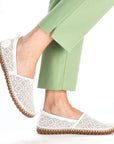 Model wearing Rieker M2851 white perforated leather flats with brown sole, styled for casual summer comfort.