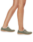 Model wearing Rieker N42G0 women's slip-on sneakers in green, showcasing stylish comfort and cushioned support for everyday use.