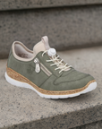 Rieker N42G0 women's slip-on sneaker displayed on outdoor steps, highlighting its casual style, bungee laces, and cushioned insole.