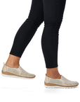 Beige slip-on shoes worn with black leggings.