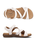 Pair of White backstrap sandals with two Velcro cross straps, tan Taos logo'd footbed and dark brown outsole.