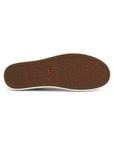Brown outsole with "taos" word as repeating tread pattern of a sneaker.