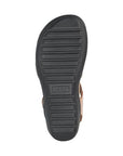 Black light treaded outsole of sandal with Taos logo stamped in middle.