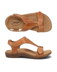 Pair of Backstrap leather sandals in tan with two adjustable Velcro straps, t-strap design, tan Taos logo'd footbed and brown rubber outsole.