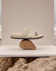 Carmela Toe Loop Sandal displayed on a rock by the beach, showcasing its balance, style, and summer-ready comfort for healthy feet.
