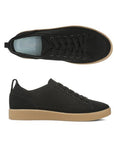 Pair of black knit sneakers with black elastic laces, blue Vionic logo'd footbed and thick tan outsole.