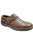 Brown slip on shoe with Velcro cross strap with metal detail and detailing stitching.