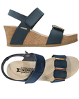 Pair of Navy wedge sandals with Velcro straps, gold bar details on toe strap, tan Mephisto logo'd footbed, cork midsole and beige outsole.