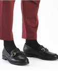 Model wearing red pants with black leather loafers.