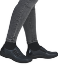 Navy slip-on shoes worn with grey jeans.