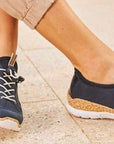 Woman wearing navy Slip-on bungee lace Sneakers with faux cork-textured midsole and white outsole.