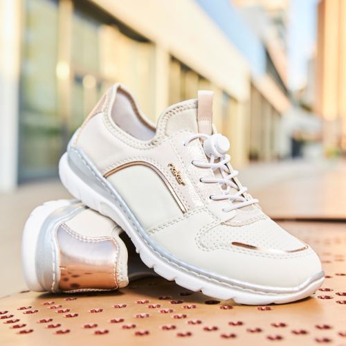 Women's Rieker L3294 Slip-On Sneakers styled outdoors, showcasing their casual design, metallic heel detail, and comfort-focused build.
