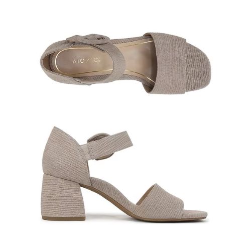 Pair of greyish beige textured leather block heels with square open toe, decorative buckle on velcro ankle strap and a tan Vionic logo'd footbed.