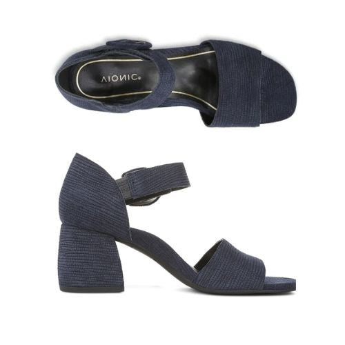 Pair of navy blue textured leather block heels with square open toe, decorative buckle on velcro ankle strap and a black Vionic logo'd footbed.