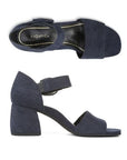 Pair of navy blue textured leather block heels with square open toe, decorative buckle on velcro ankle strap and a black Vionic logo'd footbed.