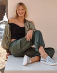 Women wearing silver Leather Loafers sitting casually at a beach.