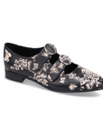 Black dress shoe with brown floral pattern and two velcro straps with detail buckles.