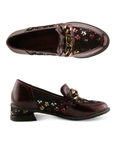 Pair of glossy burgundy leather loafers with floral pattern on the side panels, a decorative burnished gold metal rose on chain embellishment on the vamp, and black sculptured low block heel.