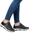 Model wearing Women's Remonte D1S01 lace-up sneakers with jeans, highlighting stylish fit, comfort, and easy-access side zipper.