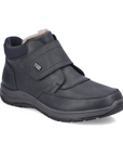 Black leather Velcro shoe with fur cuff and black treaded outsole.