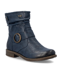 A navy blue slouchy ankle boot with a brown sole and a bronze circular metal ring detail on the side.