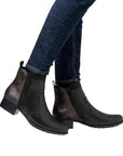 Model wearing black Rieker 78658 ankle boots with jeans, showcasing the boot's sleek leather finish and versatile fall-ready look.
