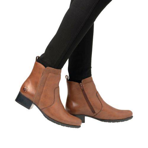Model wearing brown Rieker 78658 ankle boots with black leggings, highlighting the stylish and versatile fall boot design.