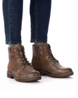 Brown leather boots worn with dark jeans.