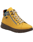 Yellow ankle boot with a zipper, beige laces, multi-color knit cuff and brown light treaded outsole.