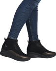 Black ankle boots worn with blue jeans.